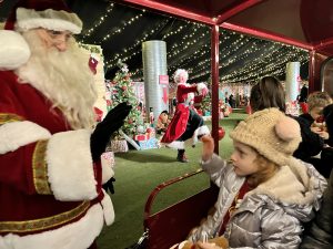 Essex Mums visits Audley End Railway Christmas Experience. Father Christmas saying hello to a child.