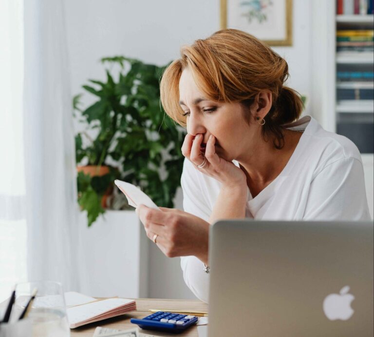 Mother with bills at desk in Essex
